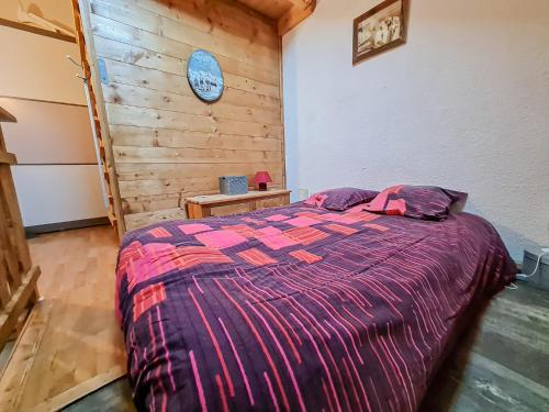 Un dormitorio con una cama y una pared de madera. en Y'Hôtes- Studio sur les hauteurs de st jeoire, en Saint-Jeoire