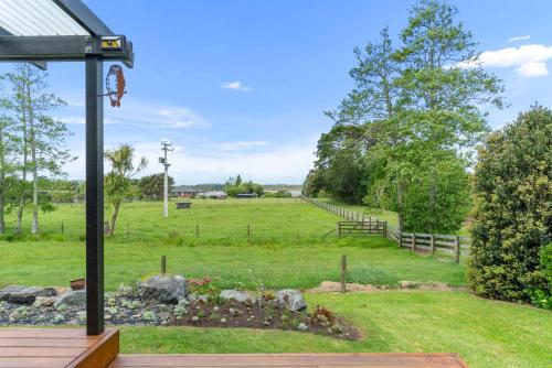 a view of a field from the porch of a house at Summer Haze - Omaha Holiday Home in Matakana