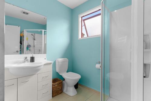 a bathroom with a toilet and a sink and a shower at Summer Haze - Omaha Holiday Home in Matakana