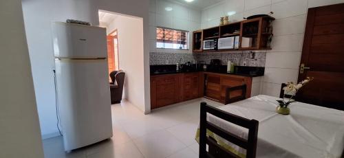 een keuken met een tafel en een witte koelkast bij Casa dos Amigos in Búzios