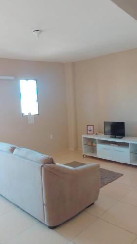 a living room with a couch and a tv at Apê perto do Parque Euclides Dourado in Garanhuns