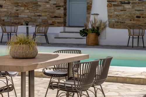 a table and chairs with a table and a pool at Onar Hotel & Suites in Tinos Town