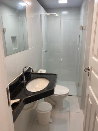a bathroom with a sink and a toilet and a shower at Apartamento térreo no Morro Branco Marina II in Beberibe