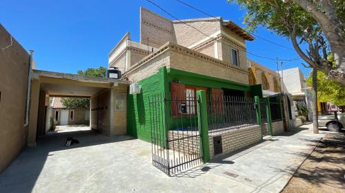 a house with a green gate in front of it at Ruca Epu in Las Grutas