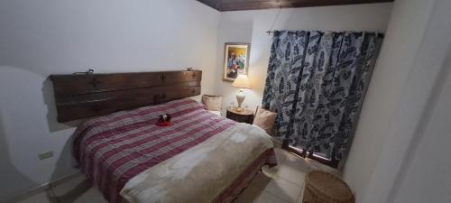 een kleine slaapkamer met een bed en een raam bij Villa Chelsey in Valle de Ángeles