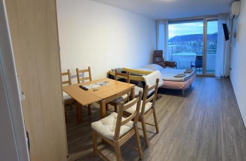 a living room with a table and a room with a bed at Reichenbach Apartment in Bad Reichenhall