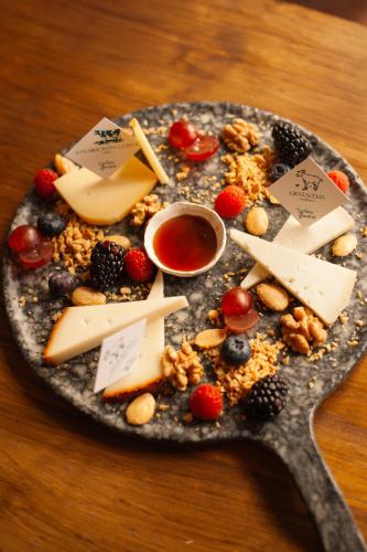 a plate of food with cheese and fruit on a table at Hotel Palacio de Hemingway in Ronda