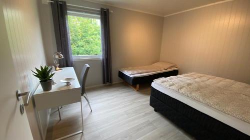 um quarto com uma cama, uma secretária e uma janela em Tunold Gård - Olahuset em Oppstryn