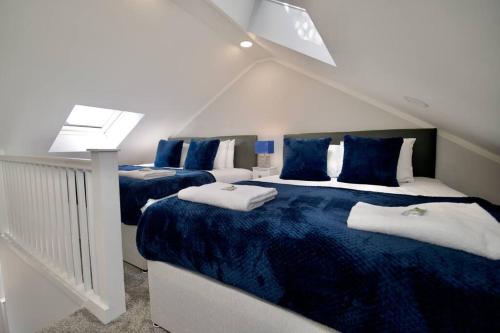 a bedroom with two beds with blue and white sheets at Dane Duplex Studio 3 – Coventry in Coventry