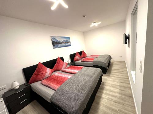 福森的住宿－TREFF APARTMENTS Füssen，客房内的两张床和红色枕头