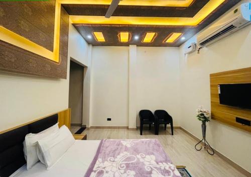 sypialnia z łóżkiem i telewizorem z płaskim ekranem w obiekcie Lotus Palm Retreat - Full Villa (By A.P. Villa's) w mieście Ujjain