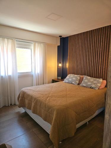 ein Schlafzimmer mit einem großen Bett und einem Fenster in der Unterkunft Apartamento Alto Padrão Uruguaiana in Uruguaiana