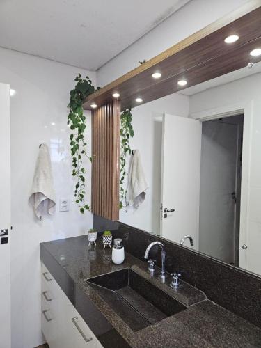 łazienka z umywalką i dużym lustrem w obiekcie Apartamento Alto Padrão Uruguaiana w mieście Uruguaiana