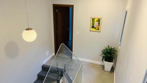 a hallway with a glass table and a potted plant at Suítes Costa Do Macacu-Garopaba in Garopaba