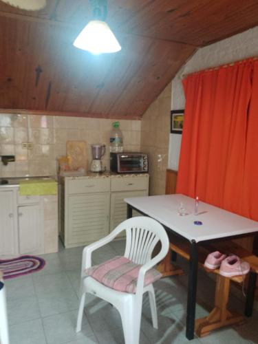 een keuken met een tafel en een witte stoel en een tafel bij Alvaro in Aguas Dulces