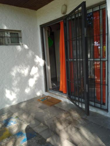 an open door of a house with an orange curtain at Alvaro in Aguas Dulces