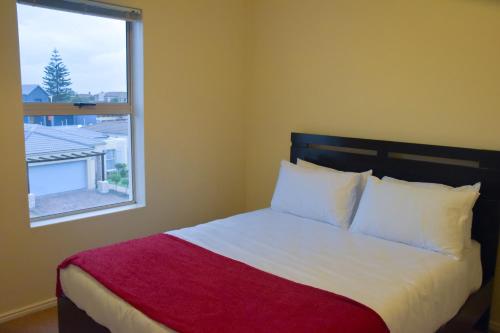 een slaapkamer met een bed en een groot raam bij 303 Formosa in Kaapstad