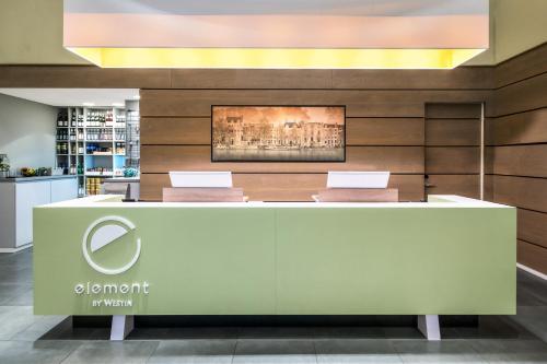 a reception desk in a store with a painting on the wall at Element Amsterdam in Amsterdam