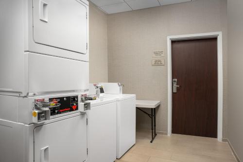 a kitchen with a refrigerator and a table and a door at SpringHill Suites by Marriott Annapolis in Annapolis