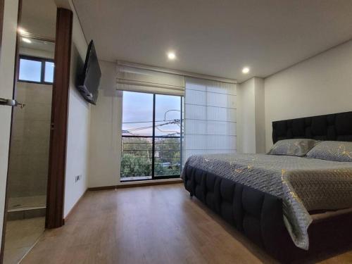 a bedroom with a large bed and a large window at Aparment comfort deluxe cajica in Cajicá