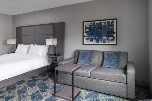 um quarto de hotel com uma cama e um sofá em Fairfield by Marriott Inn & Suites Framingham em Framingham