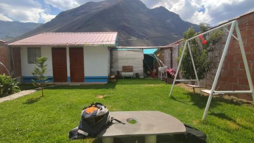 eine Tasche auf einem Tisch in einem Hof mit einem Berg in der Unterkunft Casa de Campo LA COBIJA in Calca
