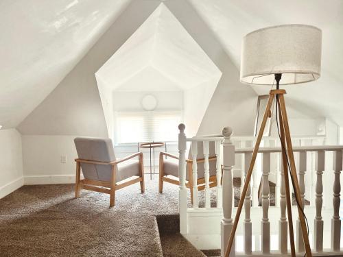 a room with a staircase with a lamp and chairs at Entire Lovely 3 Bedroom, 2 Bathroom Apartment! 1 Block to the Beach and Boardwalk! in Wildwood