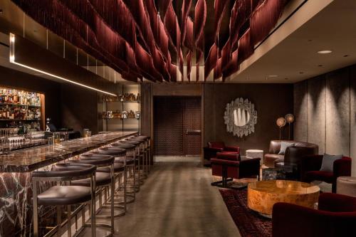 a bar with a row of bar stools at The Joseph, a Luxury Collection Hotel, Nashville in Nashville