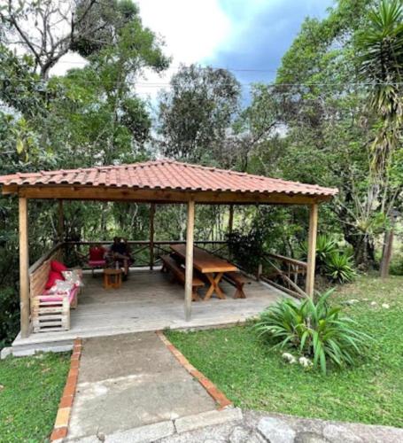 Alagoa的住宿－Pousada Uai，木制凉亭配有桌子和长凳