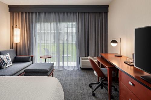 a hotel room with a bed and a desk with a computer at Courtyard by Marriott Chicago Waukegan / Gurnee in Waukegan