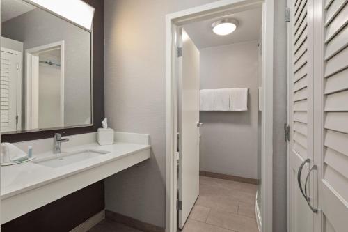 a bathroom with a sink and a mirror at Courtyard by Marriott Chicago Waukegan / Gurnee in Waukegan