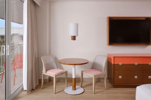 a room with a table and two chairs and a tv at Marriott Hutchinson Island Beach Resort, Golf & Marina in Stuart