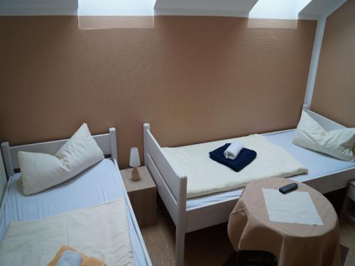 a room with two beds and a table in it at Gasthuus Ulenhoff in Westoverledingen