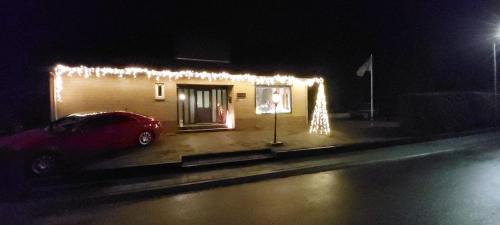 un'auto parcheggiata di fronte a una casa con luci di Os Heem a Wittem
