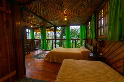 Tandayapa的住宿－Bellavista Cloud Forest Lodge & Private Protected Area，绿窗帘间内的两张床