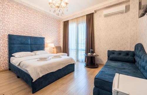 a bedroom with a blue bed and a couch at Rivendell Boutique By Umbrella in Tbilisi City