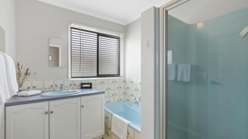 a bathroom with a sink and a glass shower at 100 on Myer in Lakes Entrance