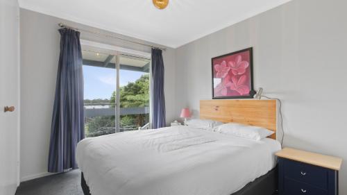 a bedroom with a large bed and a window at 100 on Myer in Lakes Entrance