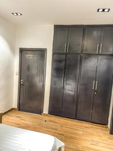 a bedroom with gray cabinets and a bed in it at Chambre Deluxe in Cotonou