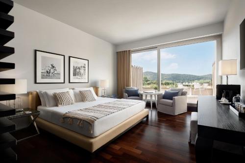 a bedroom with a large bed and a large window at Argentario Golf & Wellness Resort in Porto Ercole