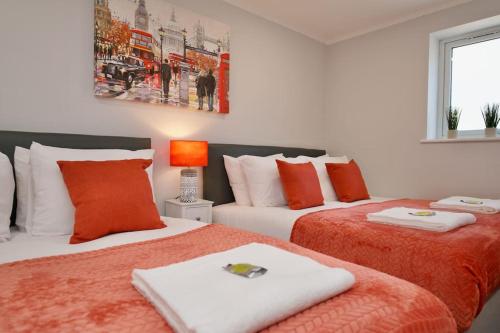 a bedroom with two beds with orange and white at Dane Apartment 11 – Coventry in Coventry
