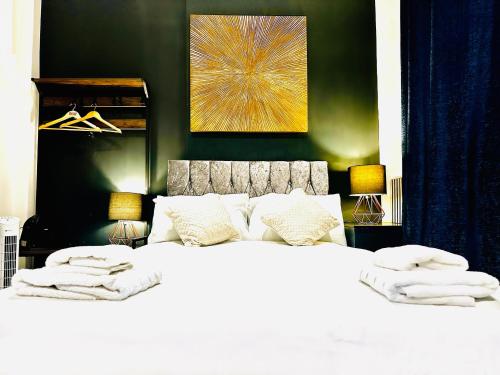 a bedroom with a large bed with white sheets and pillows at Duke and Duchess Apartments and Rooms - Private in Room Hot Tub Suites in London