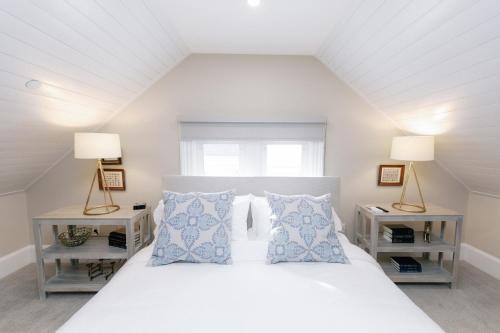 um quarto com uma cama branca com duas mesas de cabeceira em The Bell Inn em Peabody