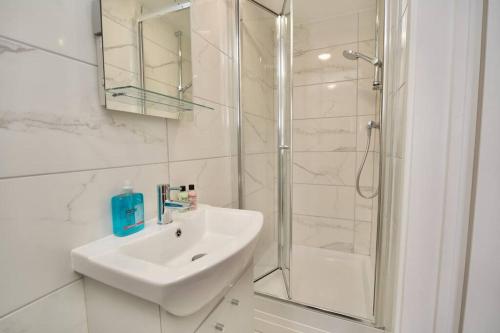 a white bathroom with a sink and a shower at Dane Apartment 12 – Coventry in Coventry