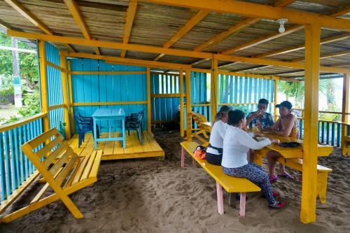 a group of people sitting at tables in a restaurant at Posada Brisas del Mar in Bahía Solano