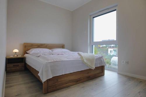 a bedroom with a bed and a large window at Apartament in Walerianowo in Walerianowo