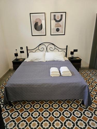 a bedroom with a bed with two towels on it at Dahlia apartment - Paola Modern Townhouse in Paola