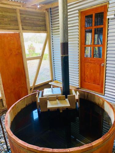 um quarto de madeira com uma mesa de madeira e uma lareira em Tiny house em Ancud