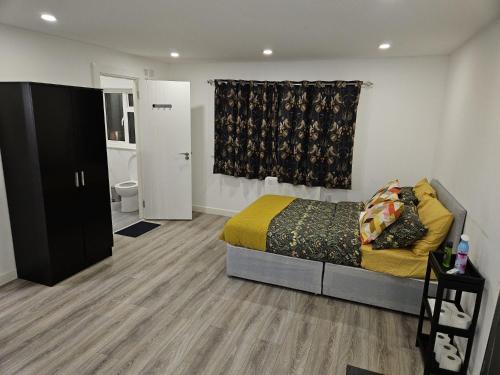 een slaapkamer met een bed en een badkamer bij A home in a room in Saint Mary Cray