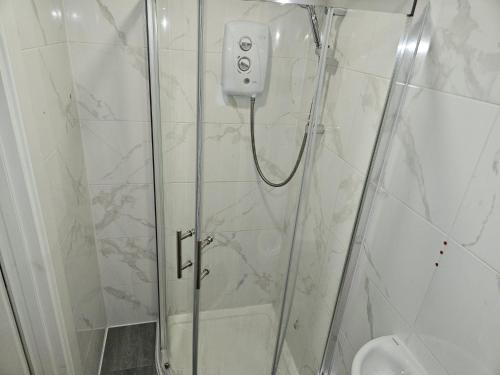 een douche met een glazen deur en een toilet bij A home in a room in Saint Mary Cray